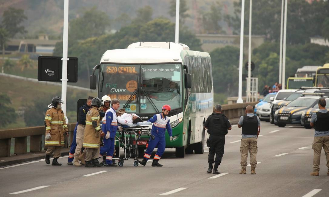 Refém é levado por policiais e equipe médica da Concessionária Foto: Fabiano Rocha / Agência O Globo