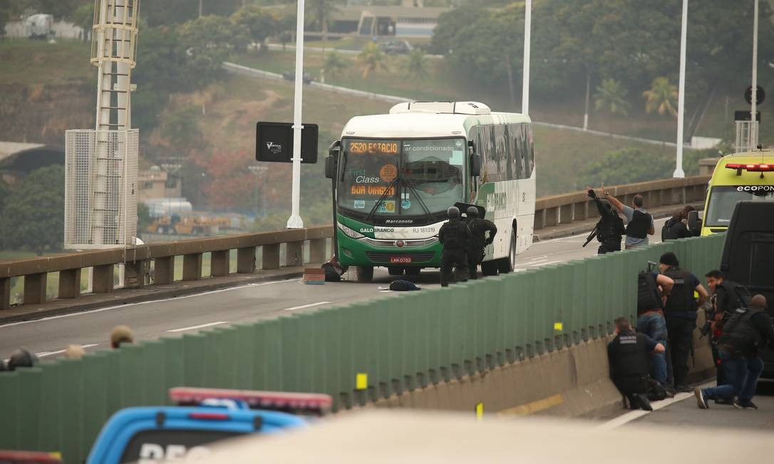 Sequestrador caído na escada do ônibus, após disparos Foto: Fabiano Rocha / Agência O Globo