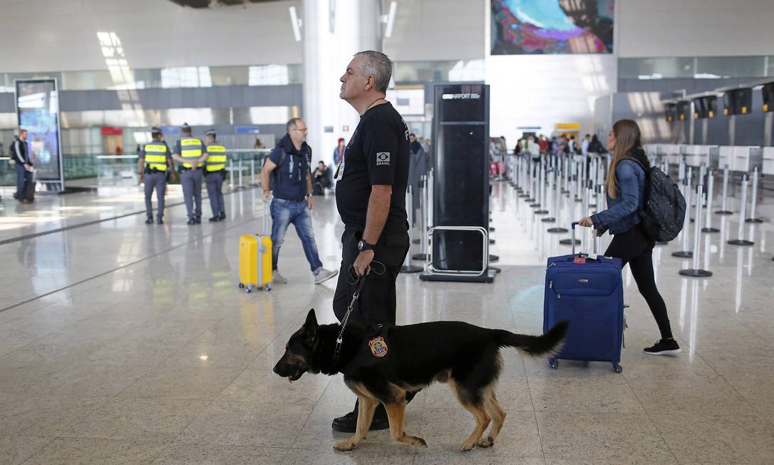 Policial federal caminha com cachorro no terminal 3 do aeroporto de Guarulhos Foto: Edilson Dantas 26/07/2016 / Agência O Globo