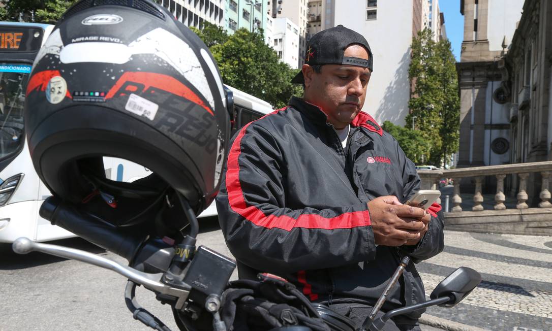 O fotógrafo André Dantas complementa a renda como mototaxista de aplicativo Foto: Pedro Teixeira / Agência O Globo