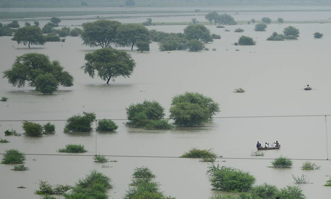 Moradores usam barcos para atravessar um rio Ganges inundado, à medida que os níveis de água nos rios Ganges e Yamuna aumentam, em Allahabad, Índia. Relatório do IPCC diz que chuvas de monção do verão indiano, uma fonte vital para regar as culturas destinadas a alimentar centenas de milhões de pessoas, enfraqueceram significativamente desde 1950, provavelmente devido ao aquecimento do Oceano Índico Foto: SANJAY KANOJIA / AFP