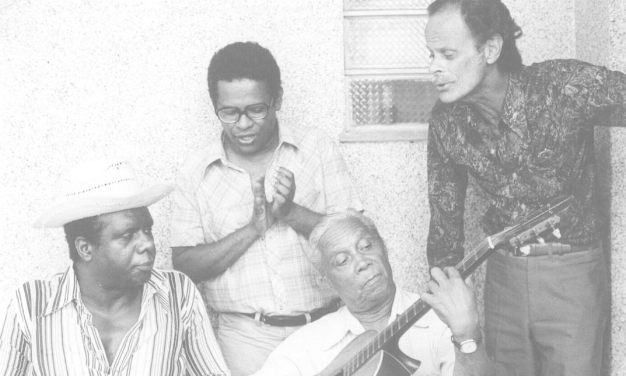 Os compositores Candeia (sentado, à esquerda), Nelson Cavaquinho (com o violão na mão), Elton Medeiros (entre os dois) e Guilherme de Brito, em março de 1977 Foto: Reprodução