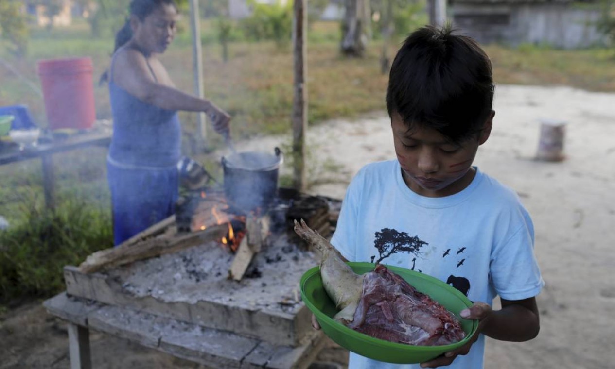 Menino com carne de caça em comunidade indígena na Bolívia Foto: Domingos Peixoto / Agência O Globo