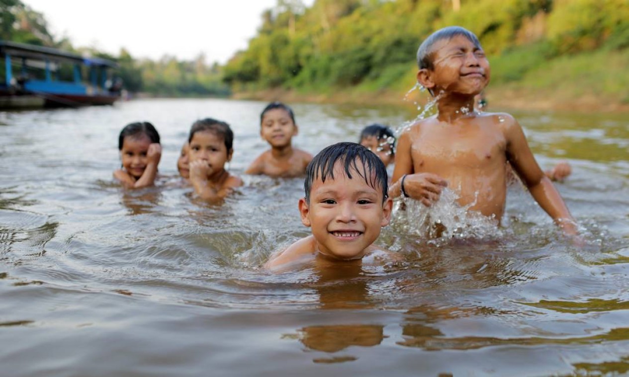 Crianças brincam em rio na comunidade das Mercedes Foto: Domingos Peixoto / Agência O Globo