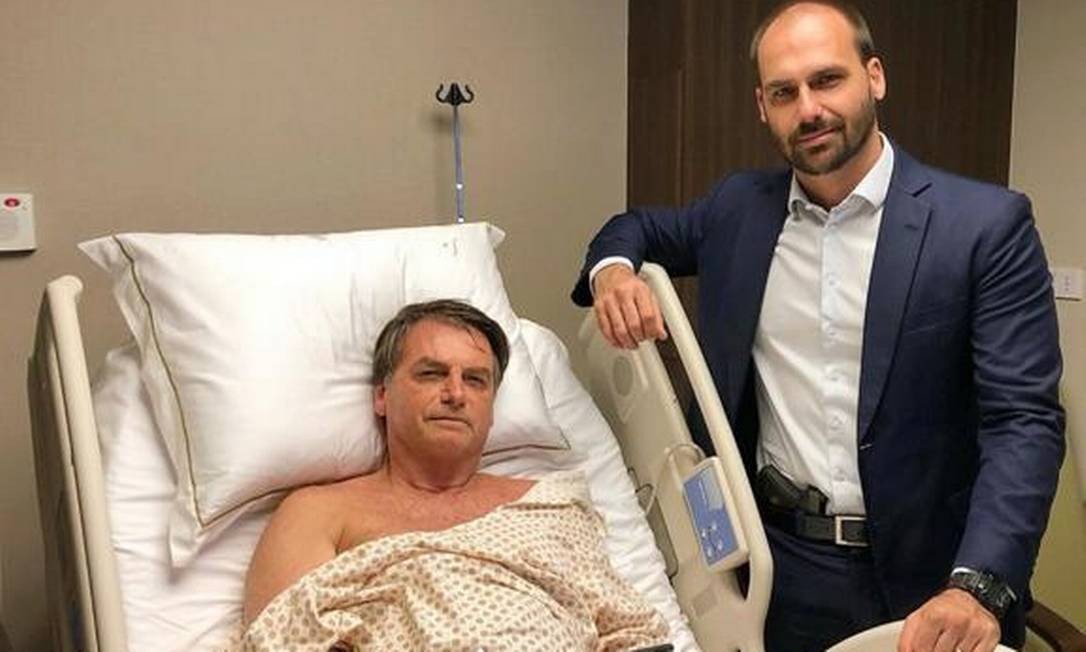 Com pistola na cintura, Eduardo Bolsonaro posa ao lado do pai em hospital