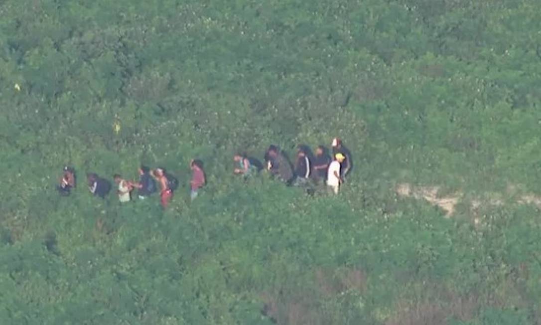 Os bandidos na trilha da Cidade de Deus, fugindo de uma operação da PM Foto: TV Globo / Reprodução