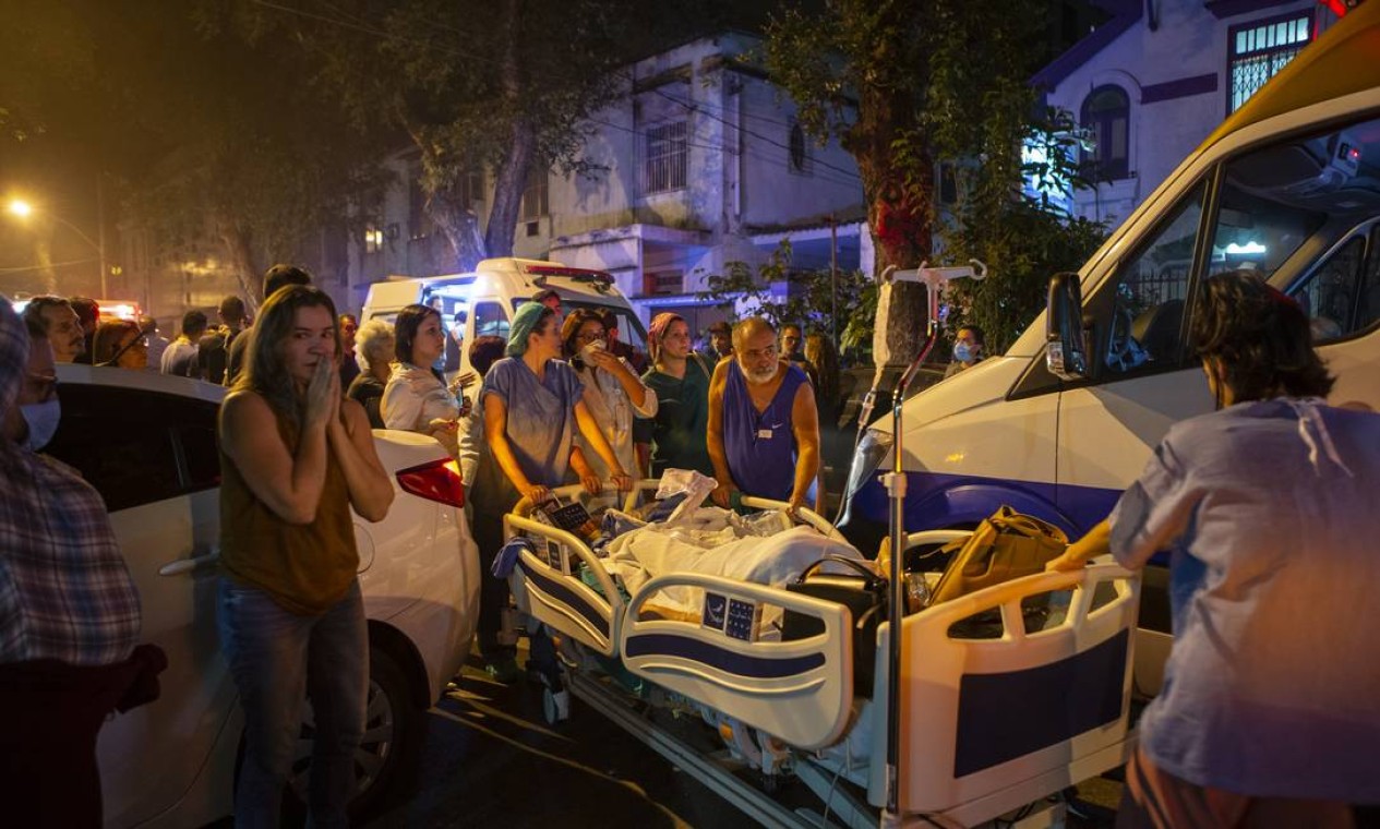 Equipe do hospital carregando pacientes que estavam na cama e não tinham como se levantar Foto: Alexandre Cassiano / Agência O Globo