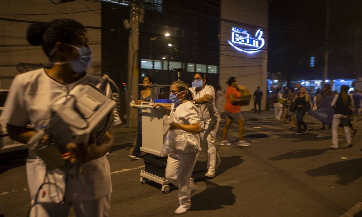 Equipamentos para manter vivos os pacientes do hospital sendo carregados por funcionários Foto: Alexandre Cassiano / Agência O Globo