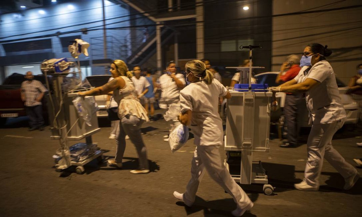 Desespero para salvar vidas, fuincionários correm com equipamentos necessários aos pacientes que foram retirados do hospital Foto: Alexandre Cassiano / Agência O Globo