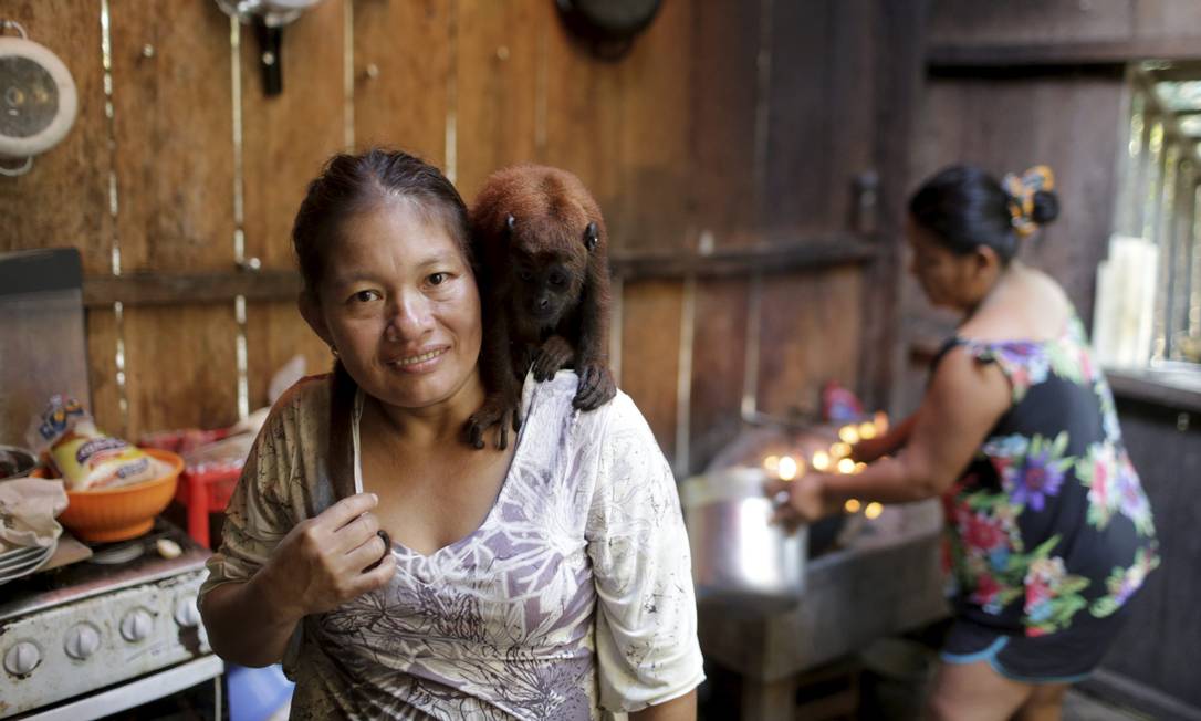 Cozinheira na comunidade Tacana, na Amazônia boliviana, Lucena Cartagena com seu macaco Moracha Foto: Domingos Peixoto / Agência O Globo