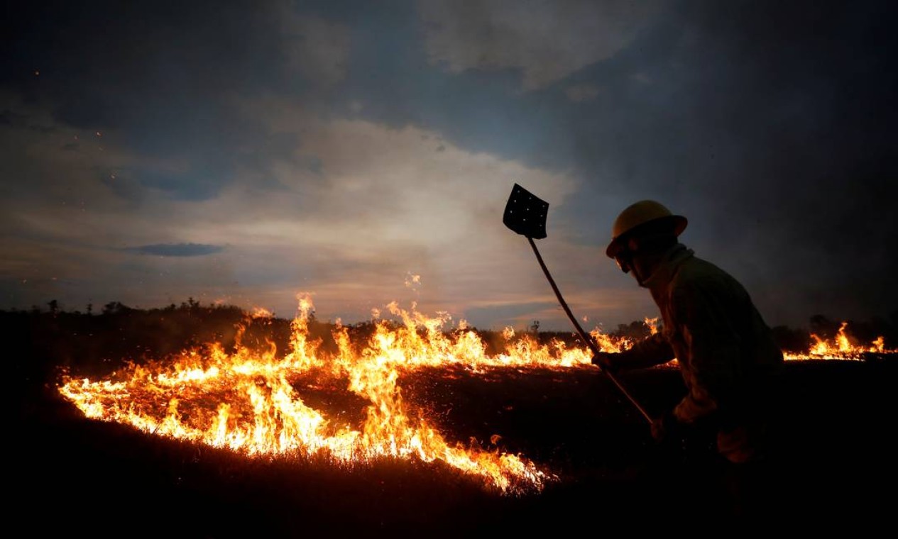 Um membro da brigada de incêndio do Instituto Brasileiro do Meio Ambiente e dos Recursos Naturais Renováveis (Ibama) tenta controlar chamas durante um incêndio na Terra Indígena Tenharim Marmelos, no estado do Amazonas, no último domingo (15) Foto: BRUNO KELLY / REUTERS