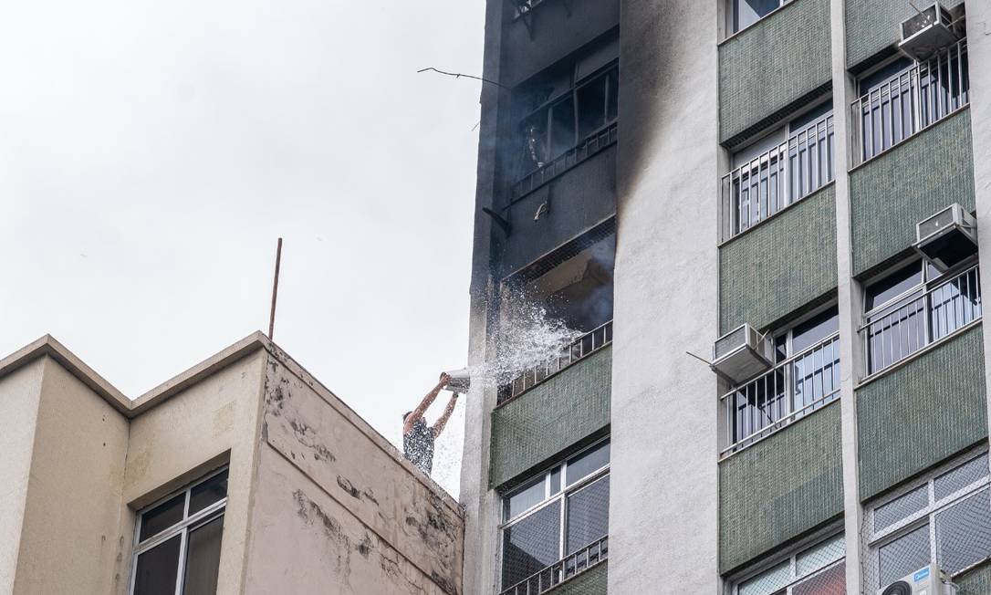 Um homem no prédio vizinho tentou controlar o incêndio com um balde de água Foto: Pedro Serra