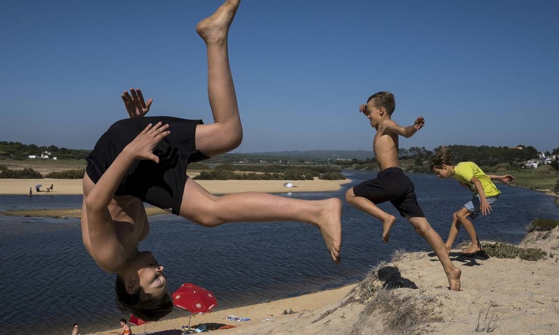 Crianças brincam na areia da Lagoa de Melides, no litoral do Alentejo, em Portugal Foto: Daniel Rodrigues / The New York Times