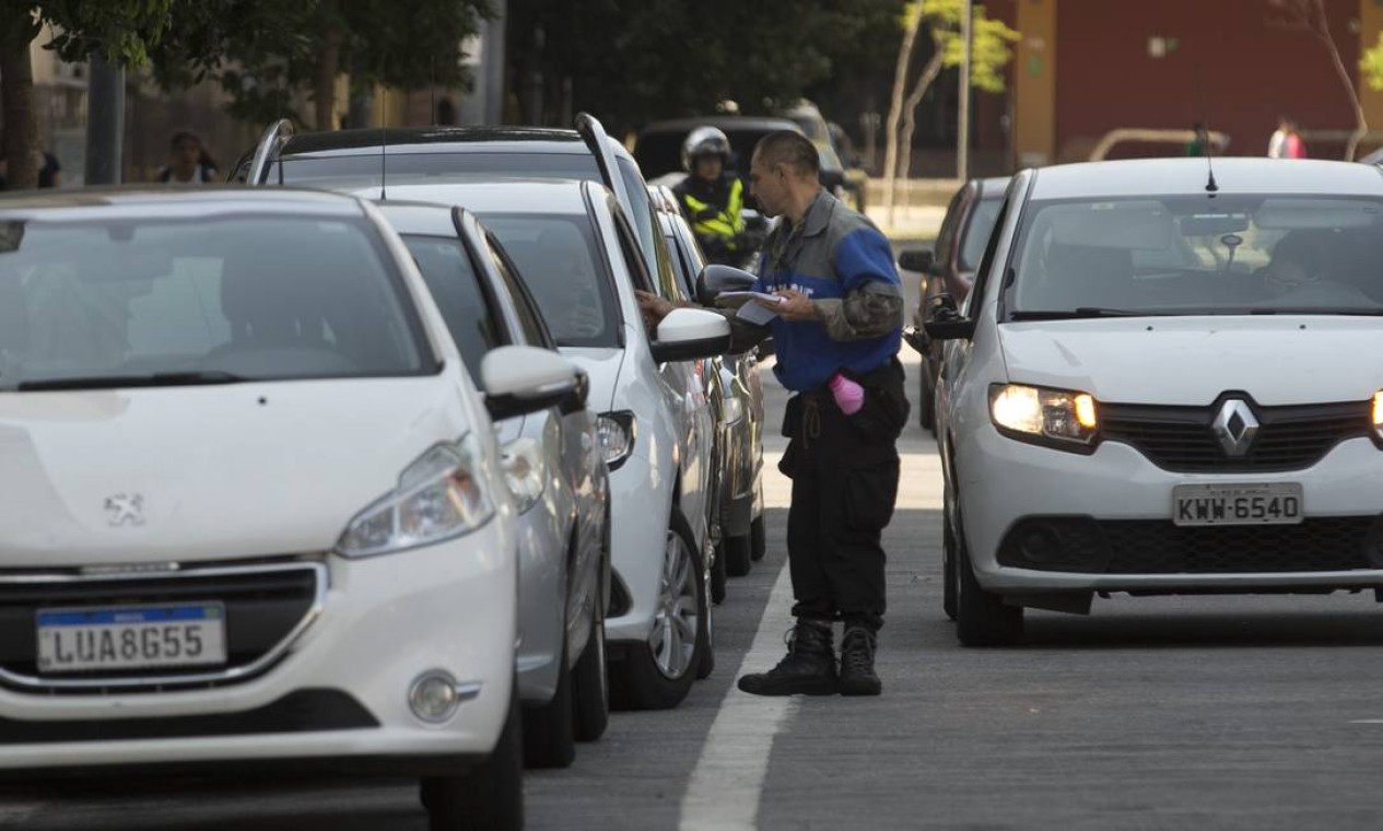 Flanelinha cobra R$ 10 para estacionar na rua Edgard Gordilho, na Zona Portuária, e dá um RPA como recibo Foto: Márcia Foletto / Agência O Globo