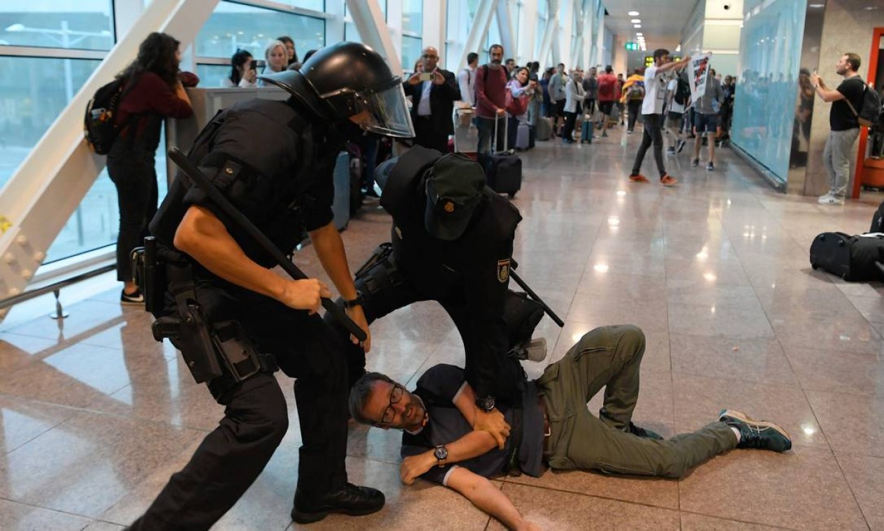 Policiais espanhóis prendem manifestante no Aeroporto El Prat, em Barcelona Foto: LLUIS GENE / AFP