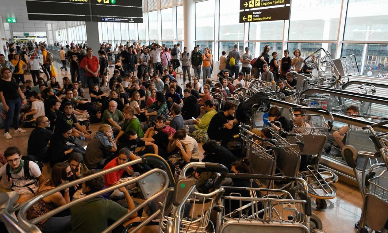 Manifestantes invadiram o Aeroporto Internacional El Prat, em Barcelona, e utilizaram carrinhos para bloquear escadas rolantes. Cerca de 120 voos foram cancelados devido ao intenso protesto Foto: LLUIS GENE / AFP