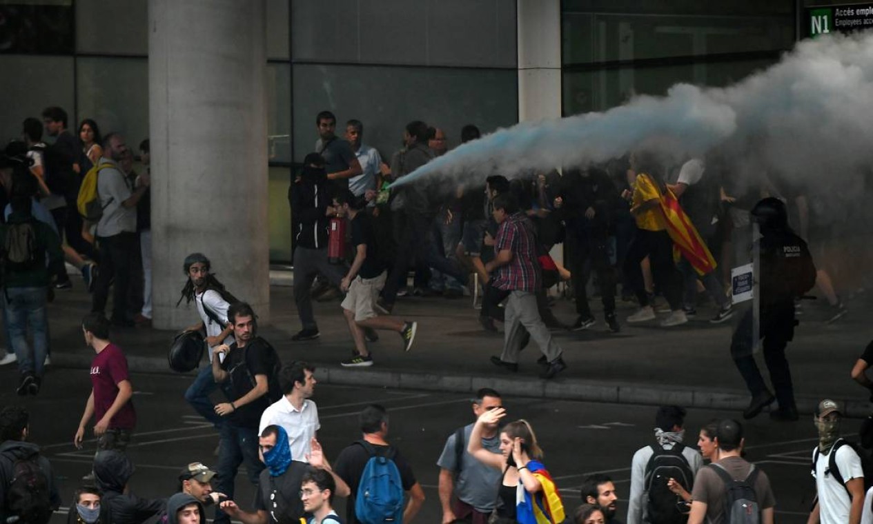 Manifestantes descarregam extintores de iincêndio nos policiiais no Aeroporto El Prat, em Barcelona Foto: LLUIS GENE / AFP