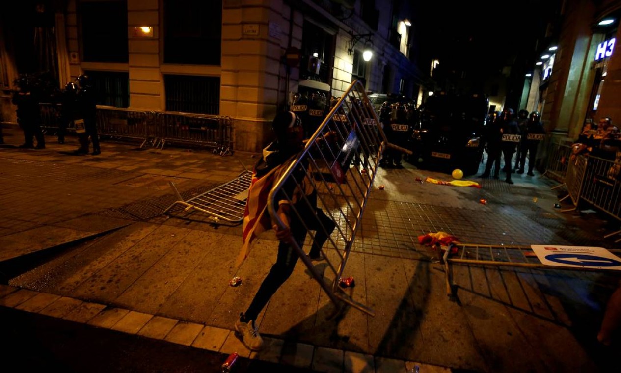 Um manifestante joga uma cerca nos confrontos com a polícia Foto: RAFAEL MARCHANTE / REUTERS