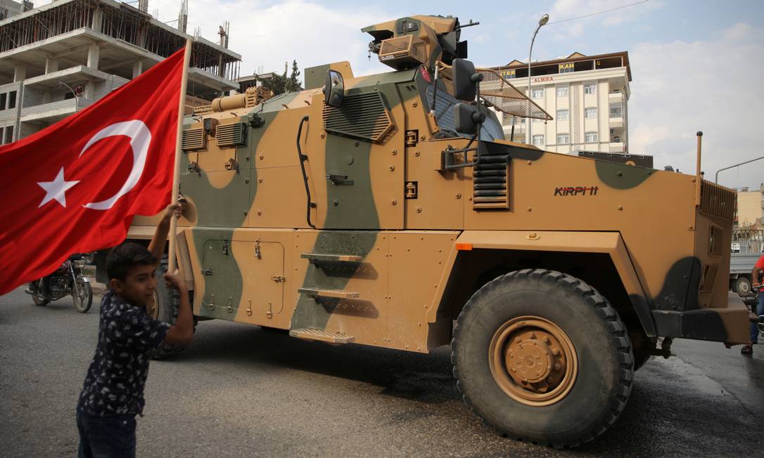 
Menino turco agita a bandeira da Turquia em apoio a tropas do país que rumam para a Síria na cidade fronteiriça de Akcakale: Trump se ofereceu para mediar acordo para evitar ‘massacre’
Foto:
STOYAN NENOV/REUTERS
