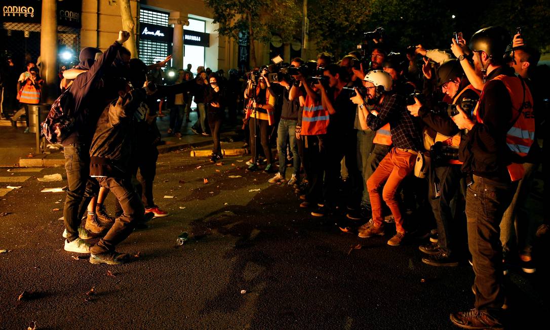 Alheios ao caos nas ruas, grupo de manifestantes posa para um grupo de jornalistas em Barcelona. Protestos chegaram à quarta noite consecutiva e prefeitura da cidade contabiliza os prejuízos Foto: RAFAEL MARCHANTE / REUTERS