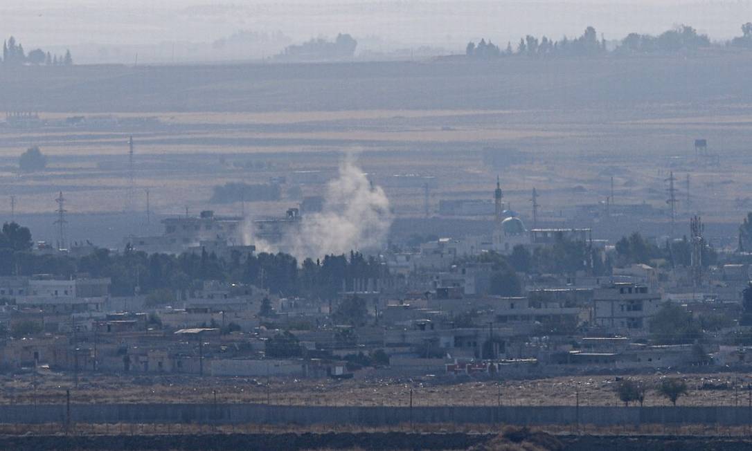 Foto tirada da cidade de Ceylanpinar, no lado turco da froneira, mostra fumaça sobre a cidade de Ras al-Ain, na Síria Foto: OZAN KOSE / AFP