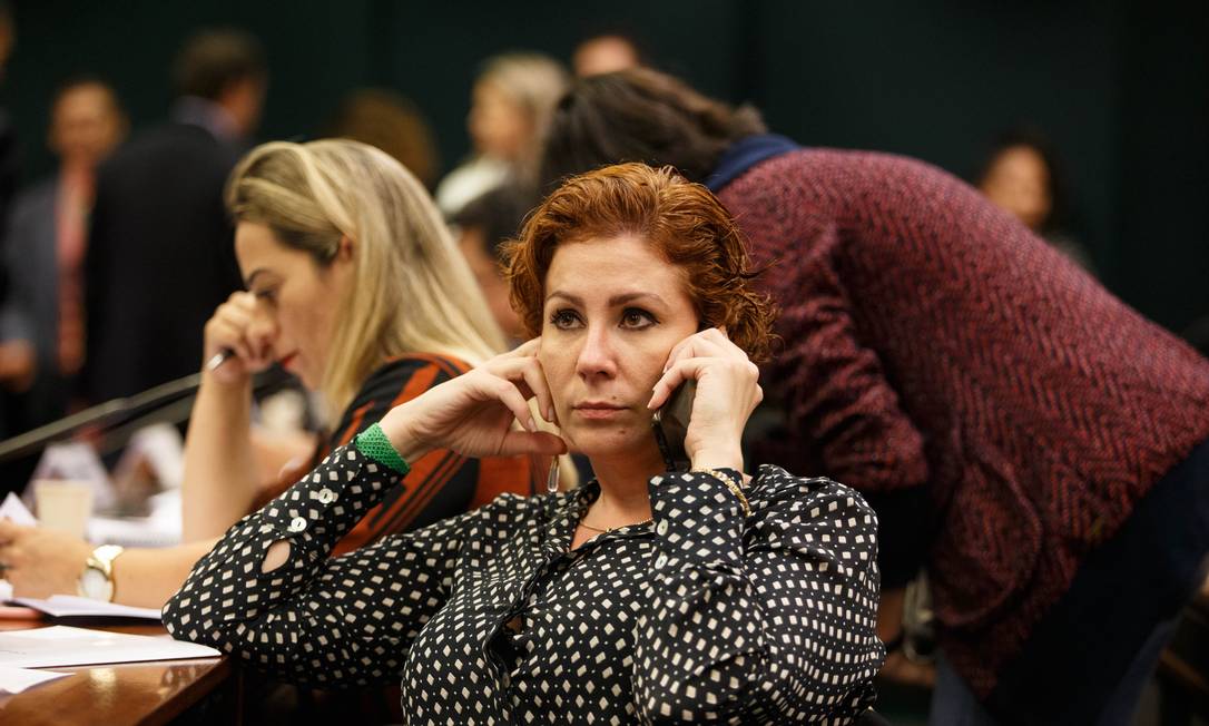 A deputada Carla Zambelli (PSL-SP) fala ao telefone durante a comissao Foto: Daniel Marenco / Agência O Globo