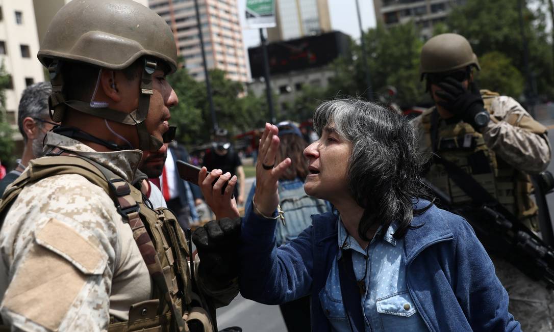Manifestante discute com militar nas ruas de Santiago, horas depois do decreto de estado de emergência na capital, uma medida que, na democracia, só foi usada em situações de desatre natural Foto: EDGARD GARRIDO / REUTERS
