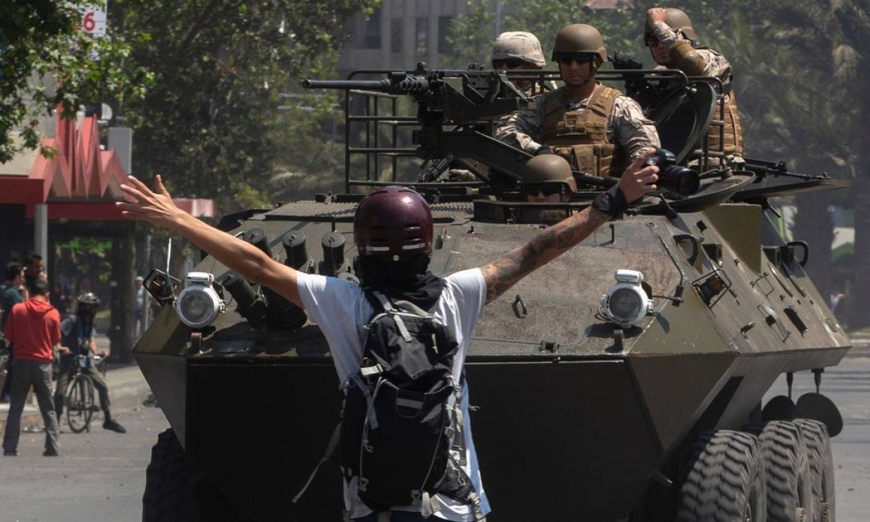 Soldados do exército armados circulando em carros blindados em Santiago Foto: CLAUDIO REYES / AFP
