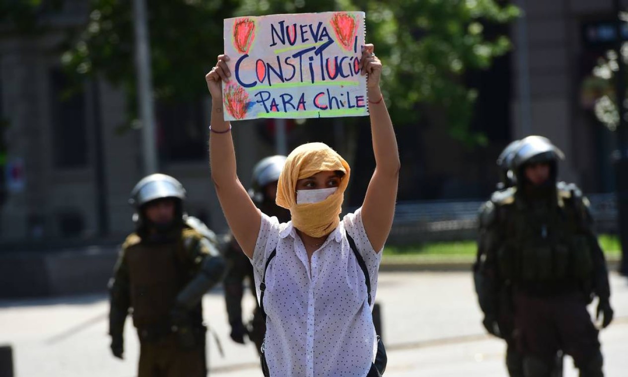 Manifestante carrega cartaz que pede nova constituição para o país Foto: MARTIN BERNETTI / AFP