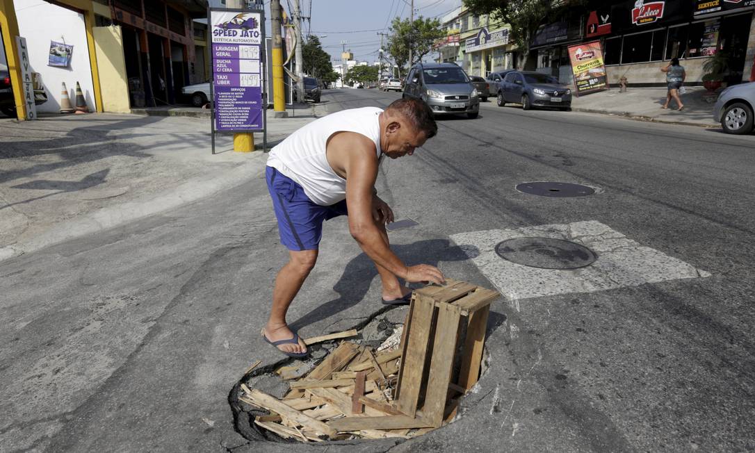Buraco no asfalto na Avenida Manuel Nogueira de Sá, em Sulacap. Queda nos investimentos prejudica manutenção Foto: Marcos Ramos / Agência O Globo