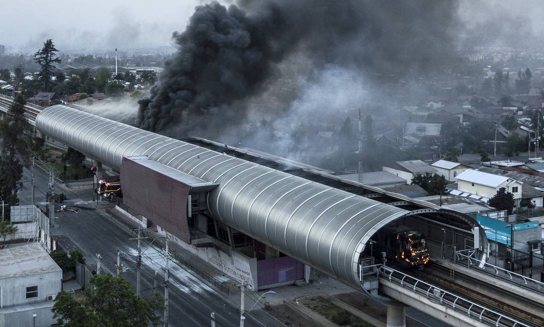 
Vista aérea de estação do metrô de Santiago em chamas: aumento das passagens foi estopim do protestos que agitaram o Chile no fim de semana
Foto:
JAVIER TORRES/AFP/19-10-2019
