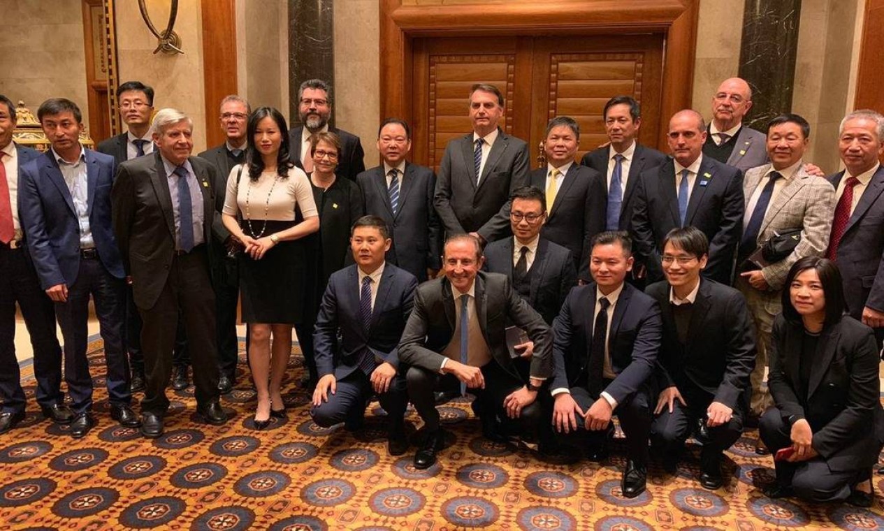 Em Pequim, na China, Bolsonaro posa para foto com ministros, secretários, o presidente da Fiesp, Paulo Skaf (agachado ao centro, sorrindo), e empresários chineses Foto: Repodução/Twitter