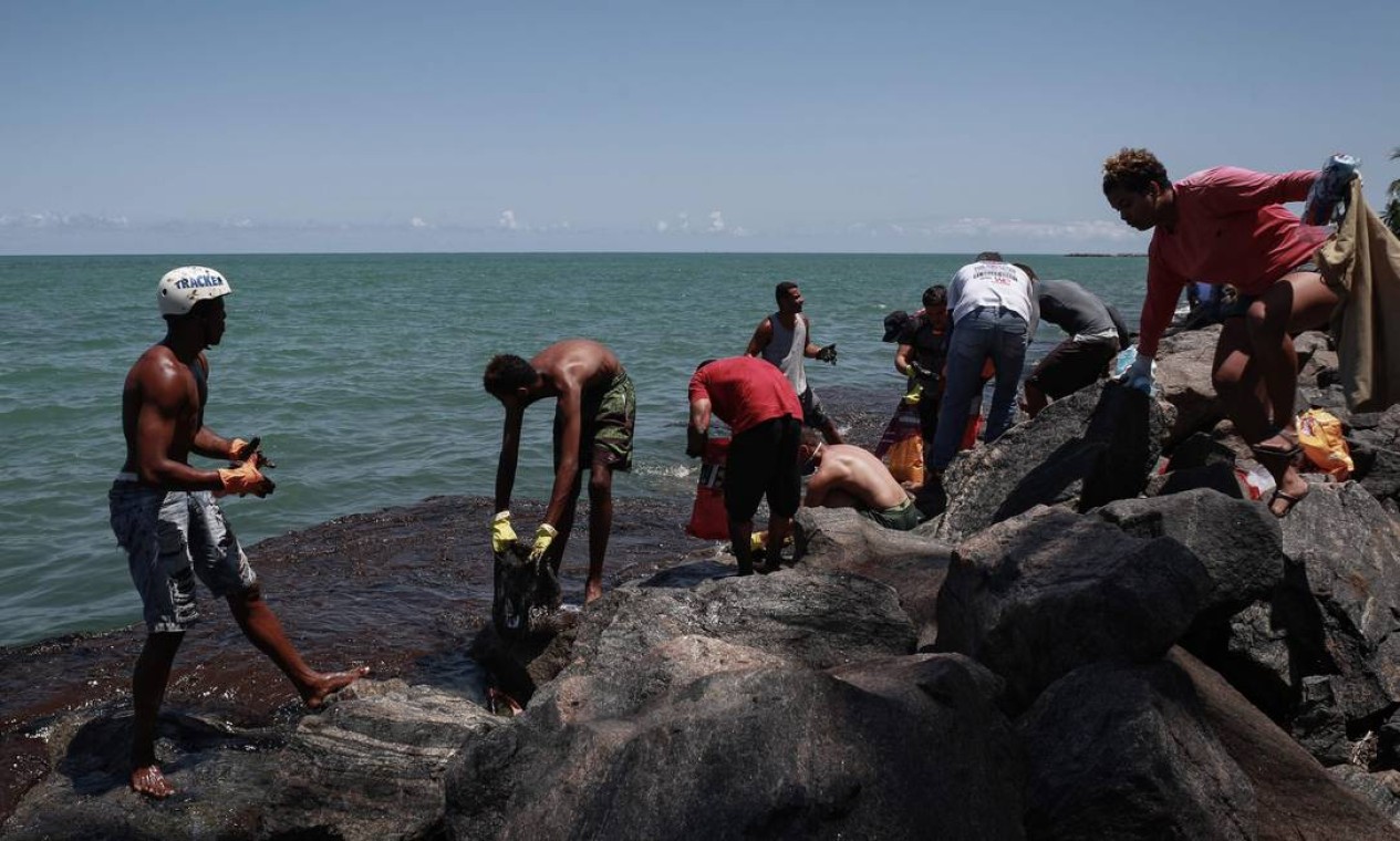 Voluntários trabalham na remoção de pretróleo da praia de Janga Foto: Leo Malafaia / AFP - 23/10/2019