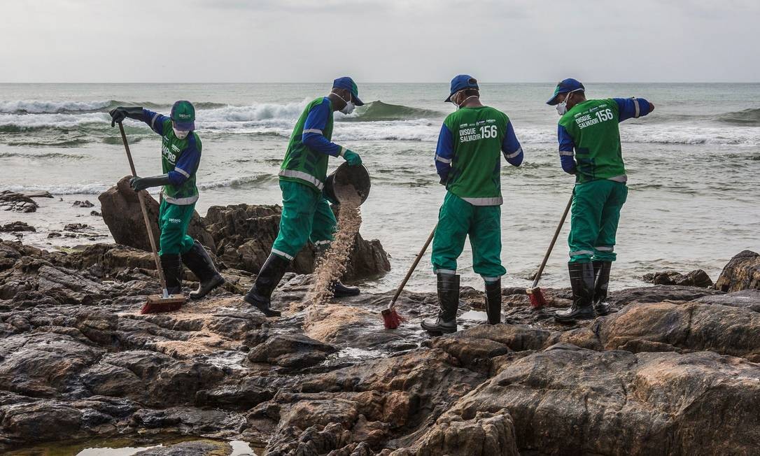 Funcionários municipais removem petróleo derramado na praia de Pedra do Sal, na Bahia Foto: Antonello Veneri / AFP - 23/10/2019