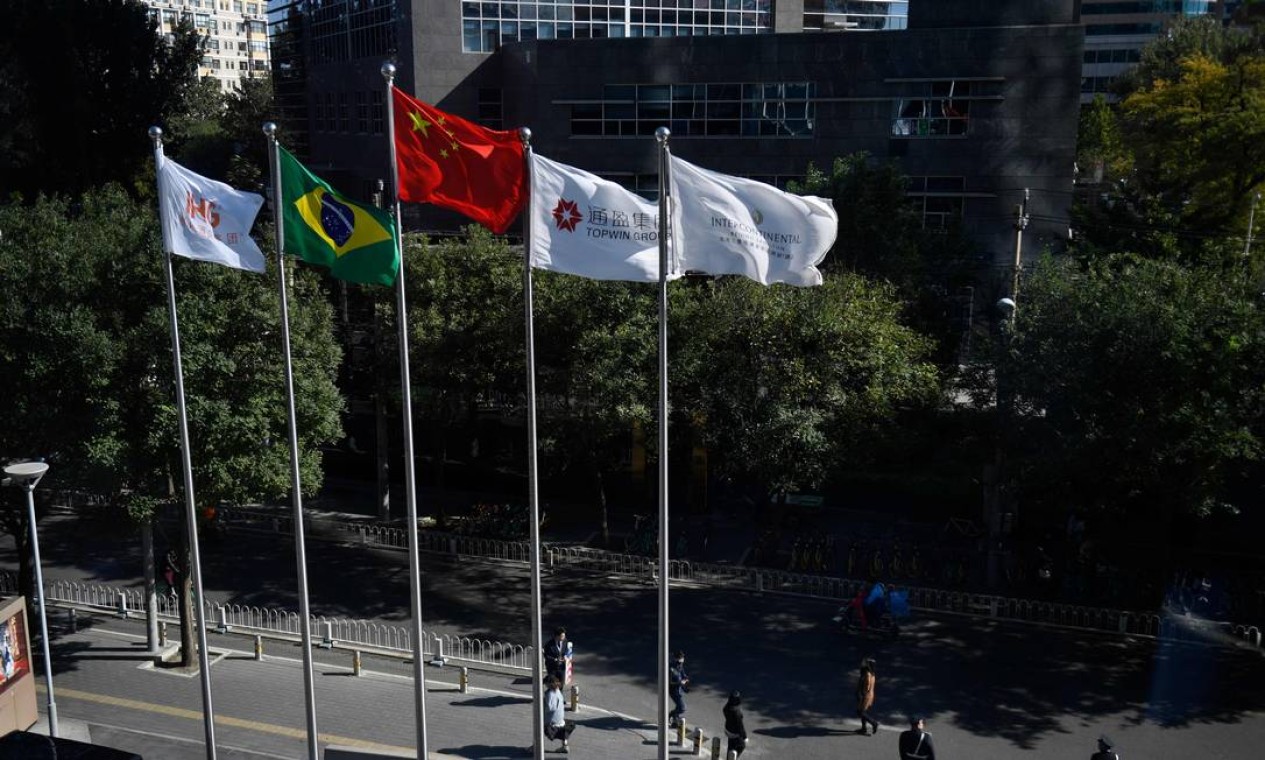As bandeiras do Brasil e da China (3ª a esquerda) na frente do prédio onde acontece o Seminário de Negócios Brasil-China, em Pequim Foto: MADOKA IKEGAMI / AFP