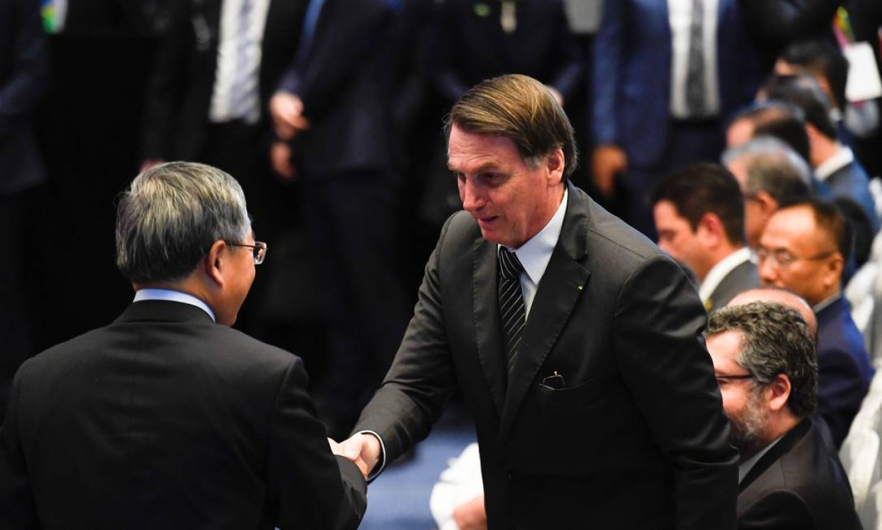 O presidente do Brasil, Jair Bolsonaro (centro), cumprimenta o vice-primeiro-ministro da China, Hu Chunhua, no Seminário de Negócios Brasil-China em Pequim Foto: POOL / REUTERS