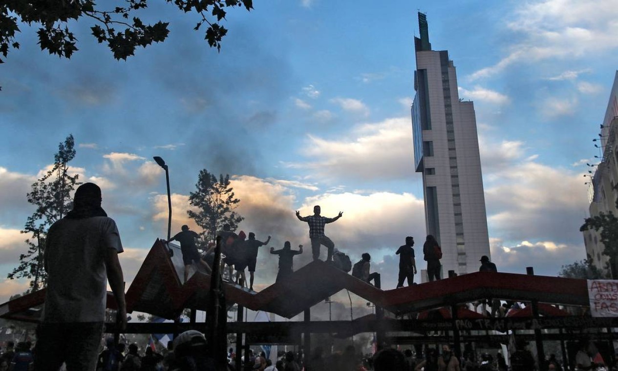 Manifestantes protestam em Santiago. O governo acenou com uma agenda social na tentativa de conter os protestos Foto: PABLO VERA / AFP