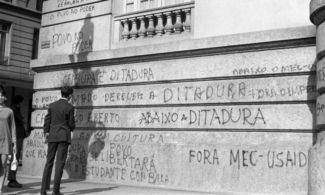 Na foto, homem lê a pichação de protesto na fachada do prédio, em maio de 1968 Foto: Arquivo / Agência O Globo