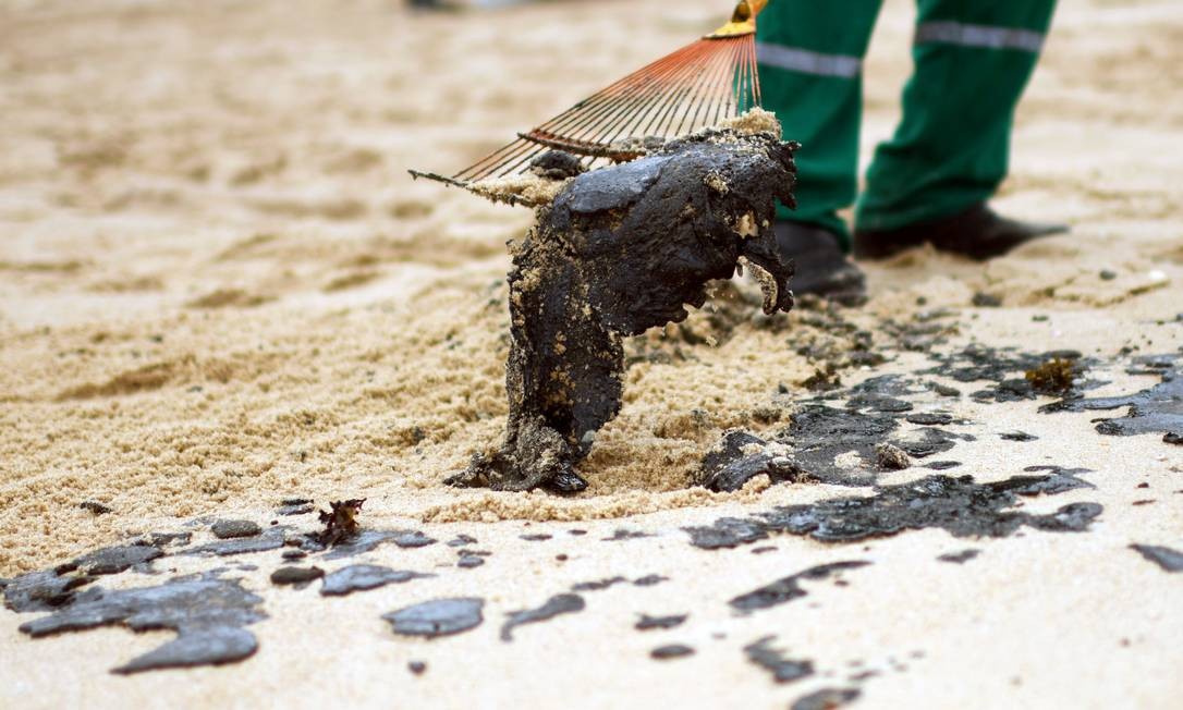 Funcionário remove resíduo de óleo na praia de Barra de Jacuipe, em Camaçari, Bahia Foto: Lucas Landau / Reuters