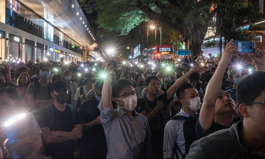 Manifestantes empunham seus celulares em ato neste sábado em Hong Kong. Polícia disparou gás lacrimogêneo e jatos d'água contra manifestantes. Foto: PHILIP FONG / AFP