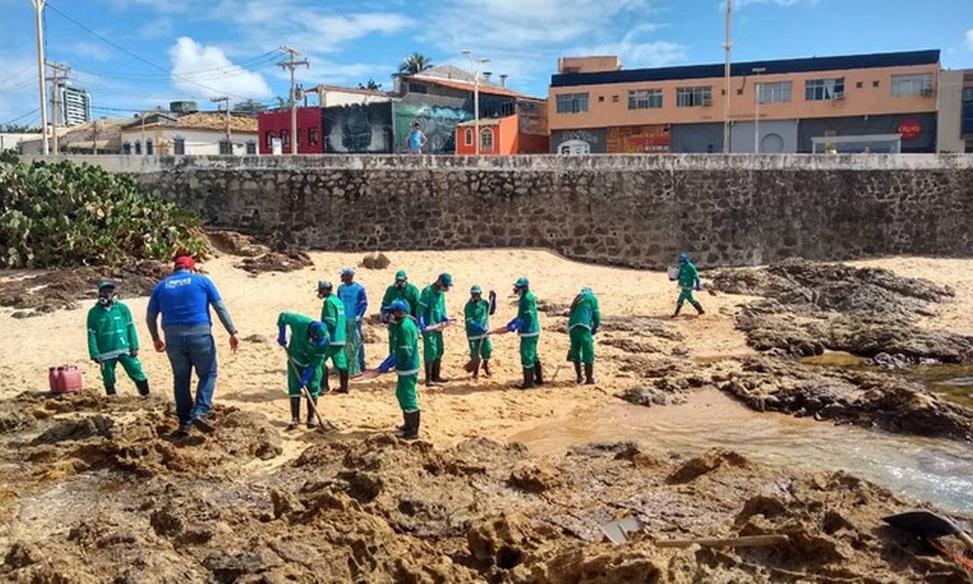 Funcionários trabalham na remoção do óleo na Praia do Rio Vermelho, em Salvador Foto: Luana Assiz/TV Bahia