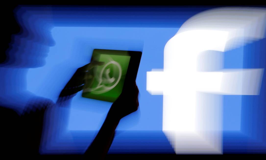 Logo do WhatsApp em frente tela com logo do Facebook Foto: David W Cerny / REUTERS
