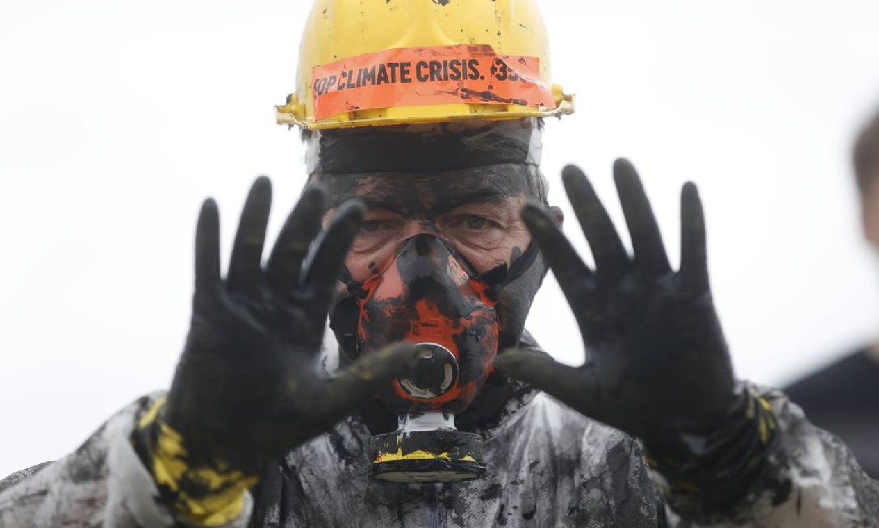 Ativista exibe mãos sujas de óleo, para alertar sobre possíveis desastres ambientais devido à exploração do petróleo Foto: Gabriel de Paiva / Agência O Globo