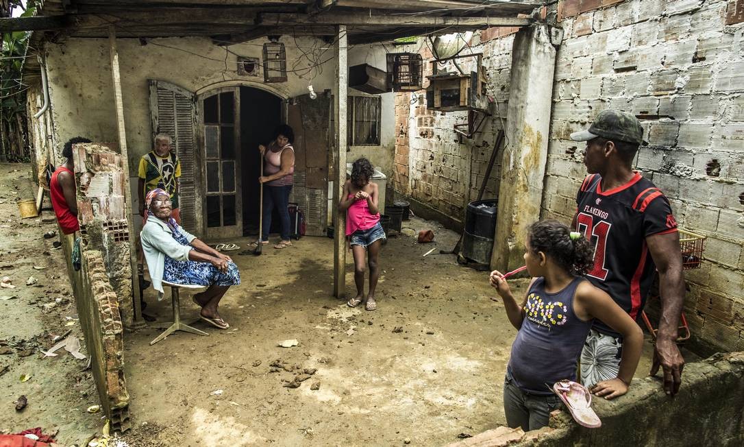 A família de Lucineia da Silva Machado no lado de fora da casa: uma criação de galinha no quintal salva as refeições Foto: Guito Moreto / Agência O Globo
