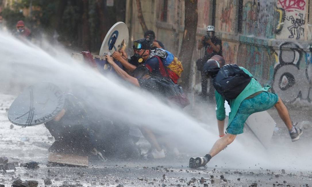 Jato d'água atinge manifestantes em protestos no Chile Foto: GORAN TOMASEVIC / REUTERS