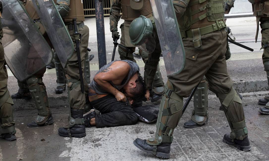 Policial puxa manifestante pelo cabelo durante protesto em Santiago Foto: PABLO SANHUEZA / REUTERS/21-11-2019
