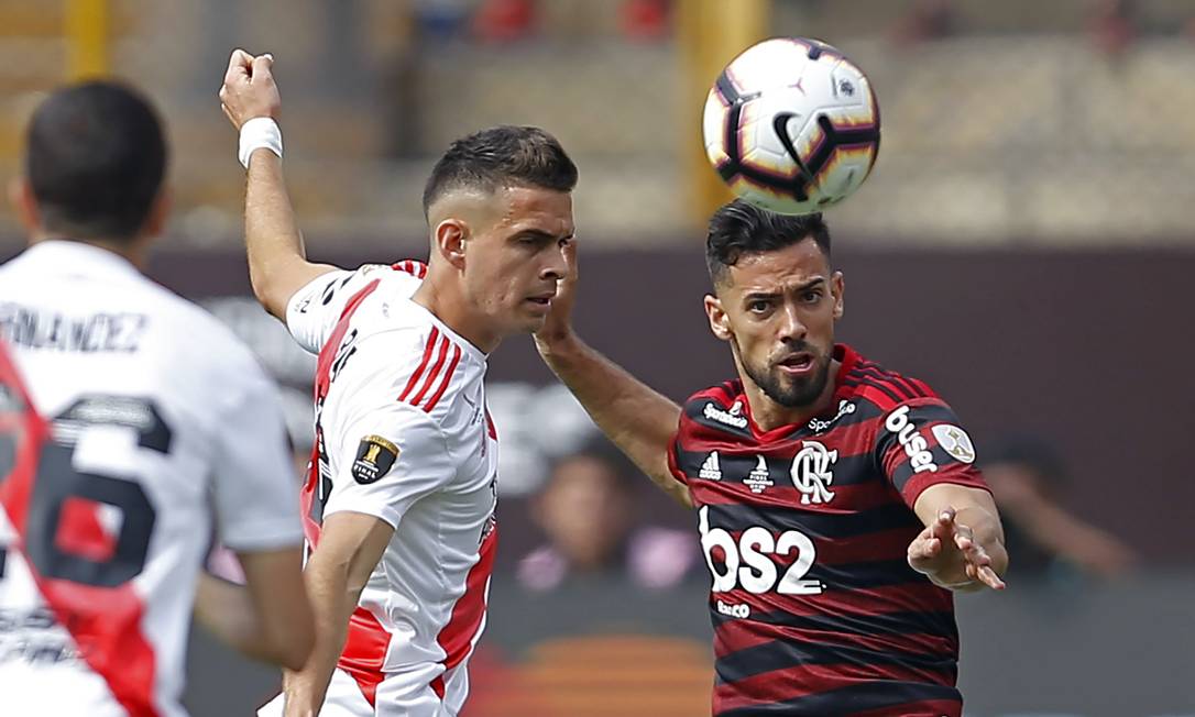 Pablo Mari, do Flamengo, e o colombiano Borré, disputam a bola pouco antes do jogador do River marcar o primeiro da partida Foto: LUKA GONZALES / AFP
