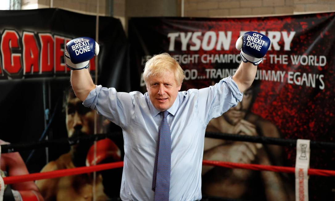 Primeiro-ministro britânico e líder do Partico Conservador, Boris Johnson veste luvas de boxe com os dizeres "Get Brexit Done". Foto: FRANK AUGSTEIN / AFP