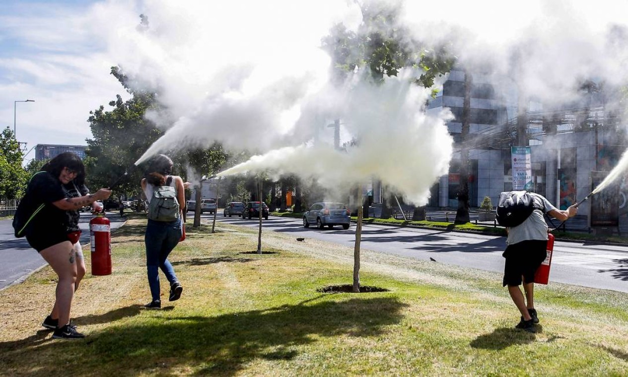Extintores de incêndio foram usados contra vizinhos em confrontos durante um protesto perto da casa do presidente chileno, Sebastián Pinera, em Santiago, neste domingo Foto: Javier Torres / AFP