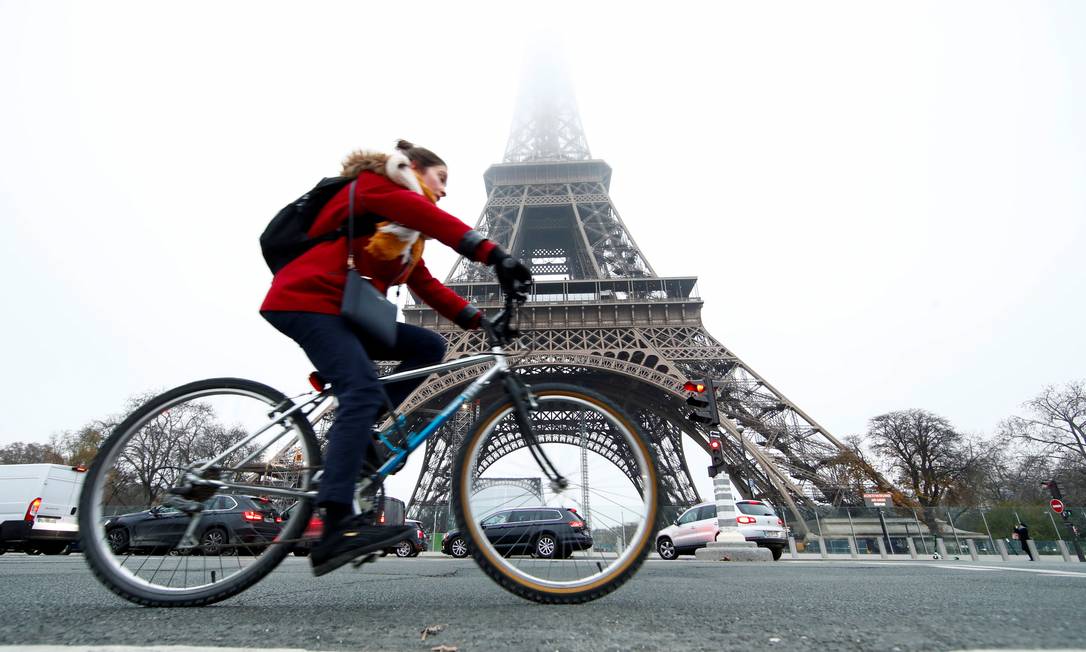 Uma mulher anda de bicicleta perto da Torre Eiffel durante o dia de greve nacional e protestos contra os planos de reforma das pensões do governo francês, em 5 de dezembro de 2019 Foto: GONZALO FUENTES / REUTERS